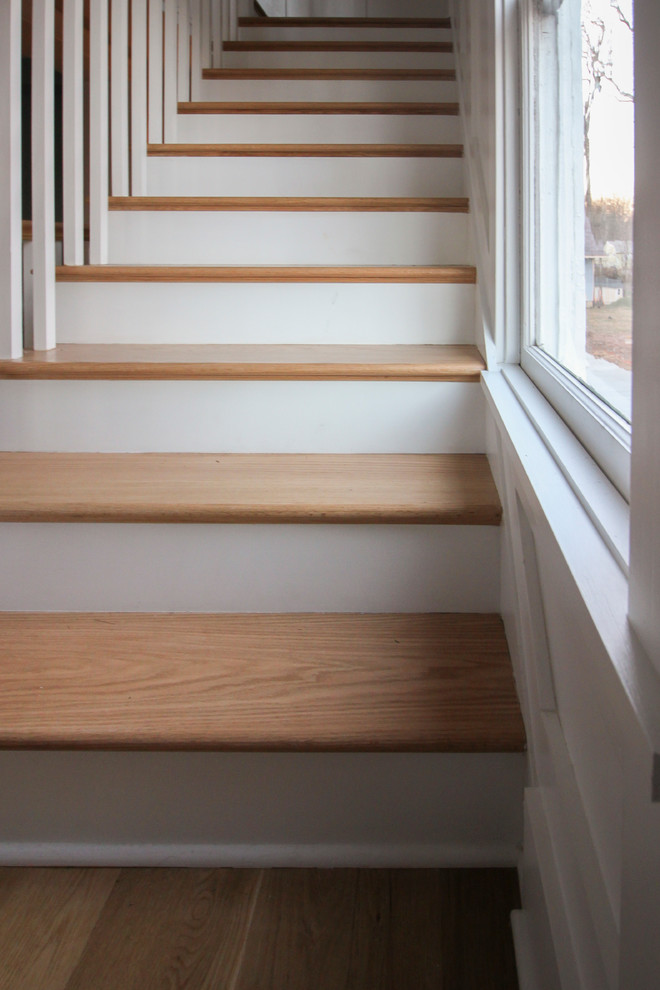 Inspiration pour un grand escalier style shabby chic en L avec des contremarches en bois, des marches en bois et un garde-corps en bois.