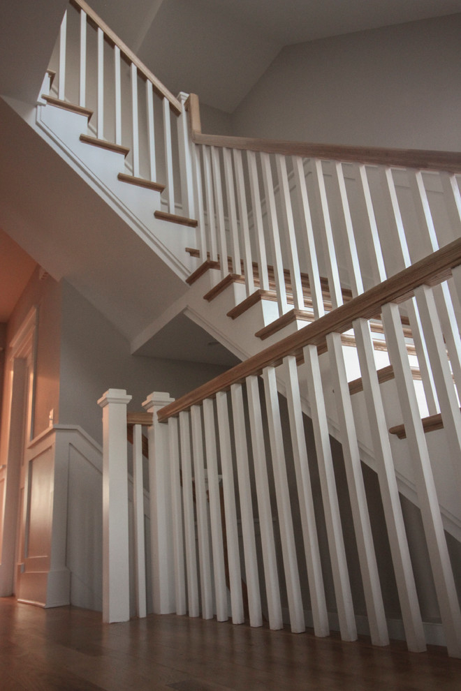 Exemple d'un grand escalier romantique en L avec des contremarches en bois, des marches en bois et un garde-corps en bois.