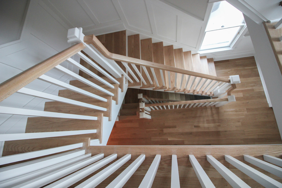 Стильный дизайн: большая угловая деревянная лестница в стиле шебби-шик с деревянными ступенями и деревянными перилами - последний тренд
