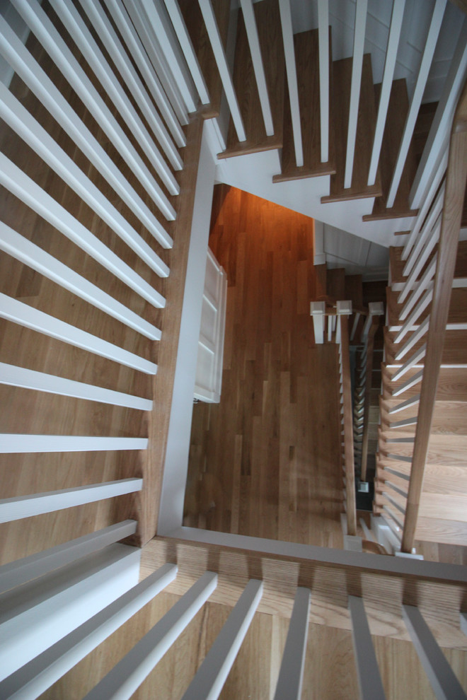 Imagen de escalera en L romántica grande con contrahuellas de madera, escalones de madera y barandilla de madera