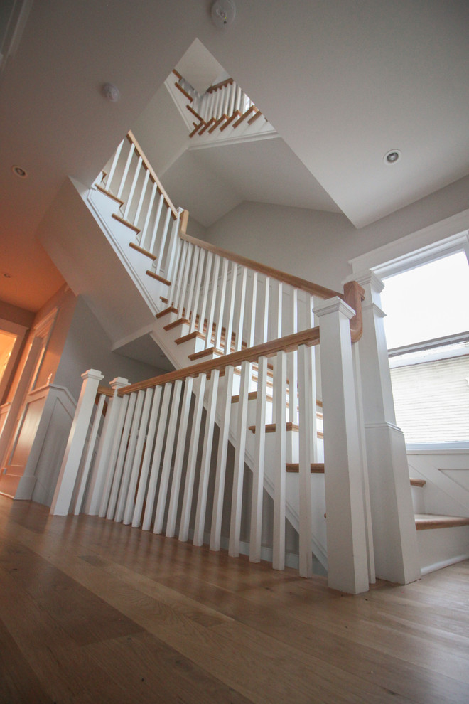 Aménagement d'un grand escalier romantique en L avec des contremarches en bois, des marches en bois et un garde-corps en bois.