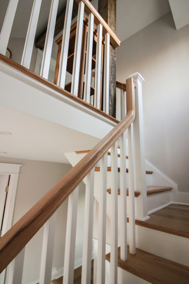 Ejemplo de escalera en L romántica grande con contrahuellas de madera, escalones de madera y barandilla de madera