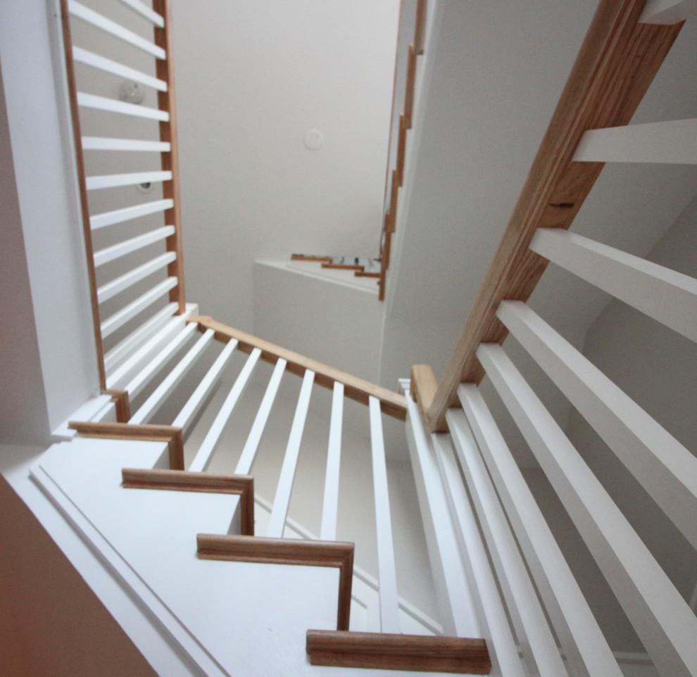 Réalisation d'un grand escalier style shabby chic en L avec des contremarches en bois, des marches en bois et un garde-corps en bois.