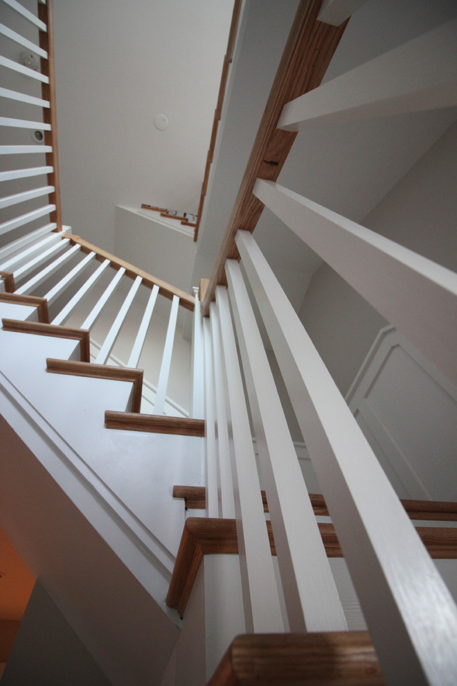На фото: большая угловая деревянная лестница в стиле шебби-шик с деревянными ступенями и деревянными перилами