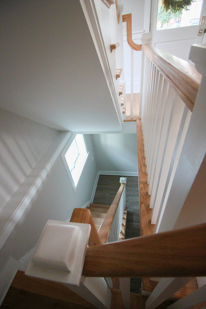 ワシントンD.C.にある高級な広いシャビーシック調のおしゃれなかね折れ階段 (木の蹴込み板、木材の手すり) の写真