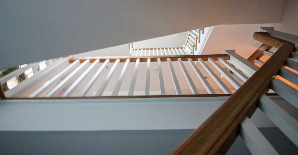 Immagine di una grande scala a "L" shabby-chic style con alzata in legno, pedata in legno e parapetto in legno