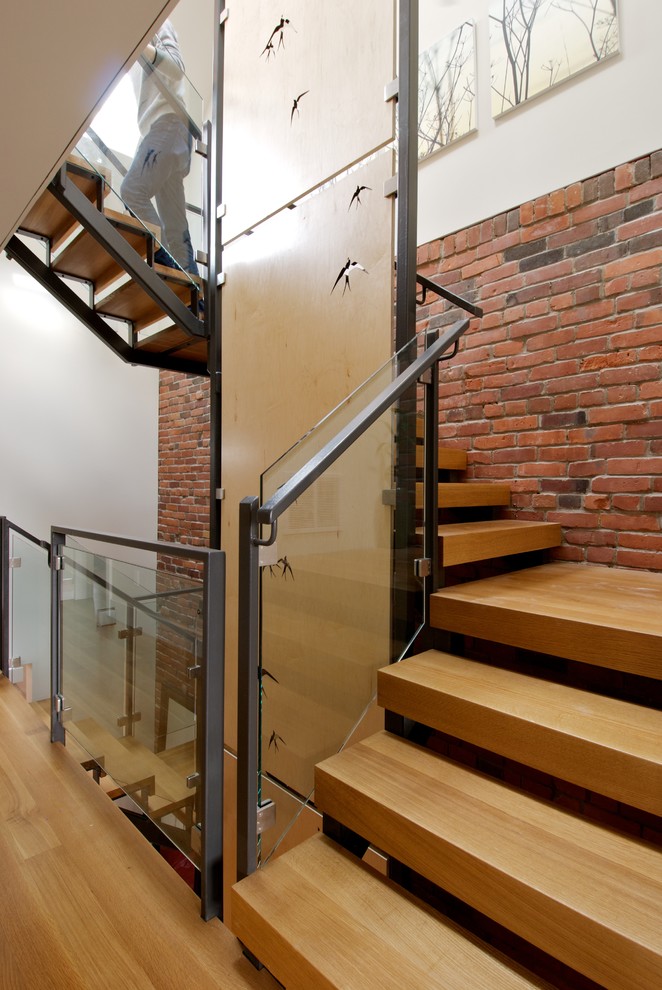 Photo of a medium sized modern wood curved metal railing staircase in Toronto with open risers.