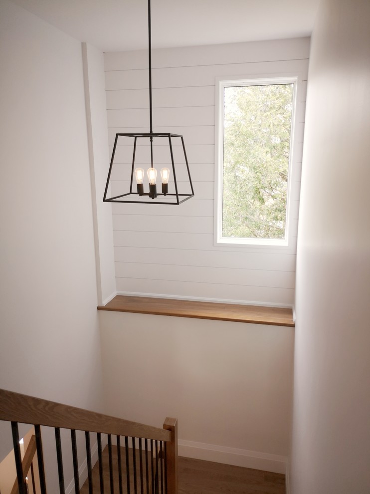 Diseño de escalera en U campestre de tamaño medio sin contrahuella con escalones de madera y barandilla de metal