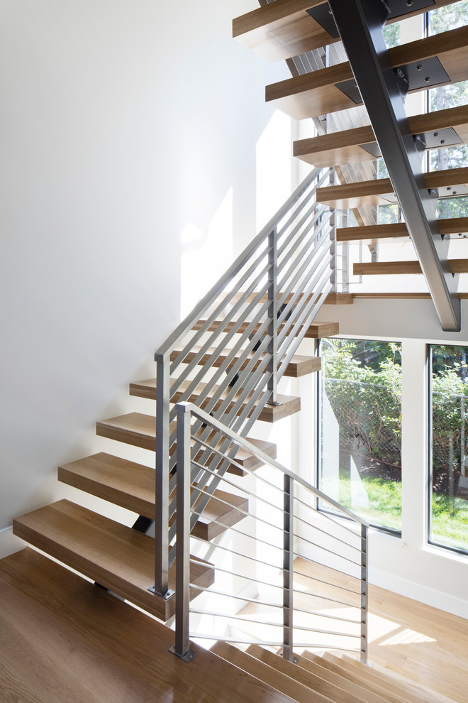 Réalisation d'un grand escalier sans contremarche minimaliste en U avec des marches en bois.