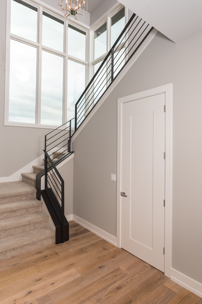 Cette image montre un grand escalier design en U avec des marches en moquette et des contremarches en moquette.
