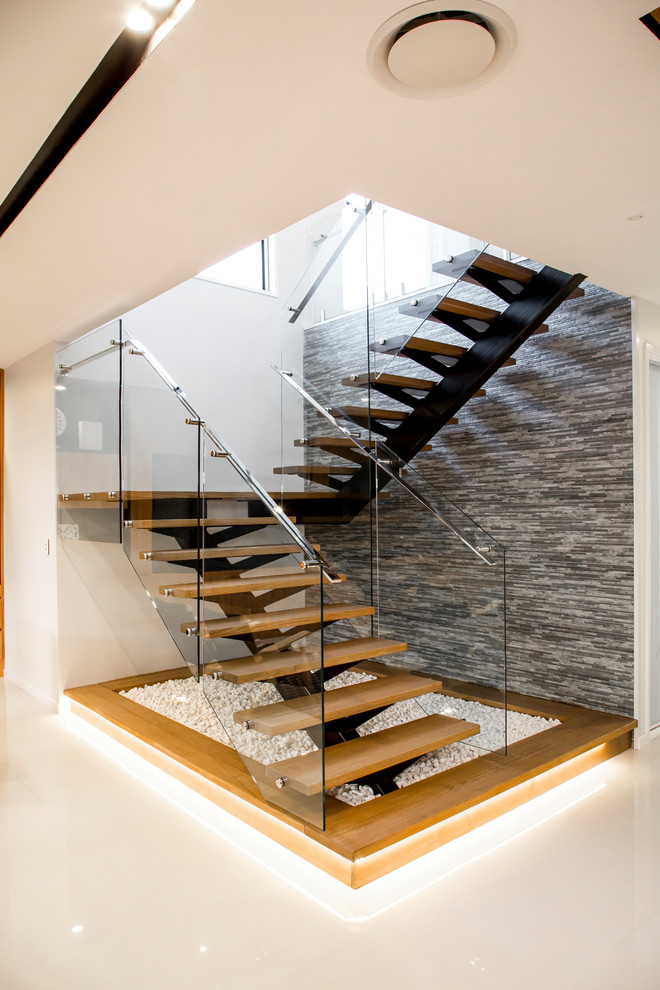 Foto di una scala a "U" minimalista di medie dimensioni con parapetto in vetro, pedata in legno e nessuna alzata