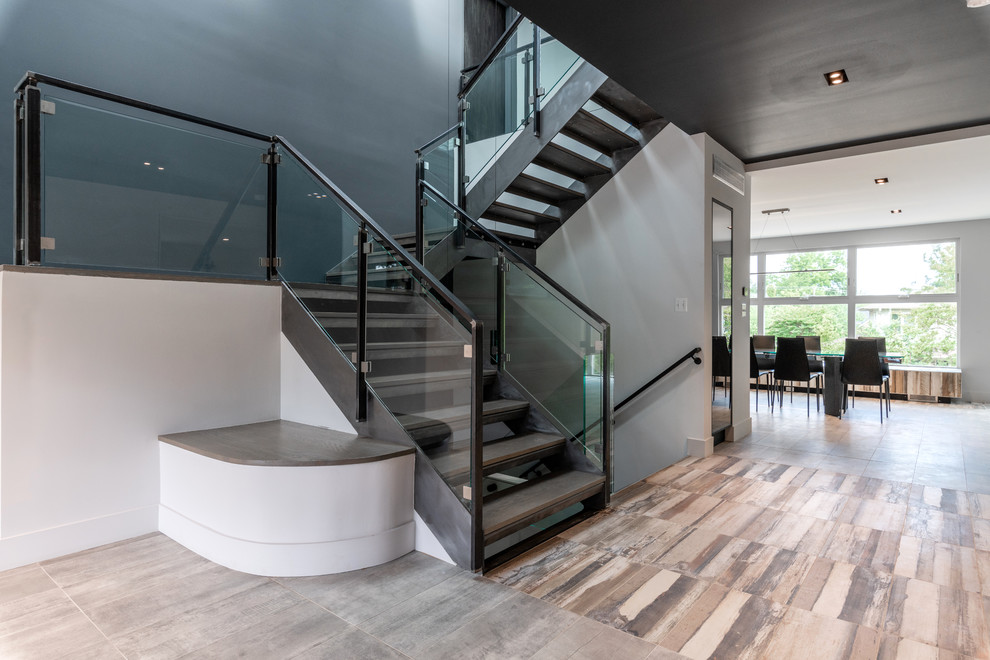 Источник вдохновения для домашнего уюта: большая п-образная лестница в стиле модернизм с деревянными ступенями и стеклянными перилами без подступенок