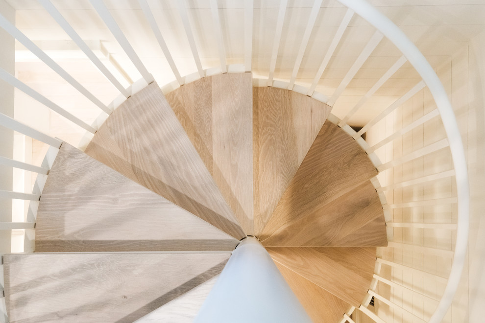 Inspiration for a small timeless wooden spiral open and metal railing staircase remodel