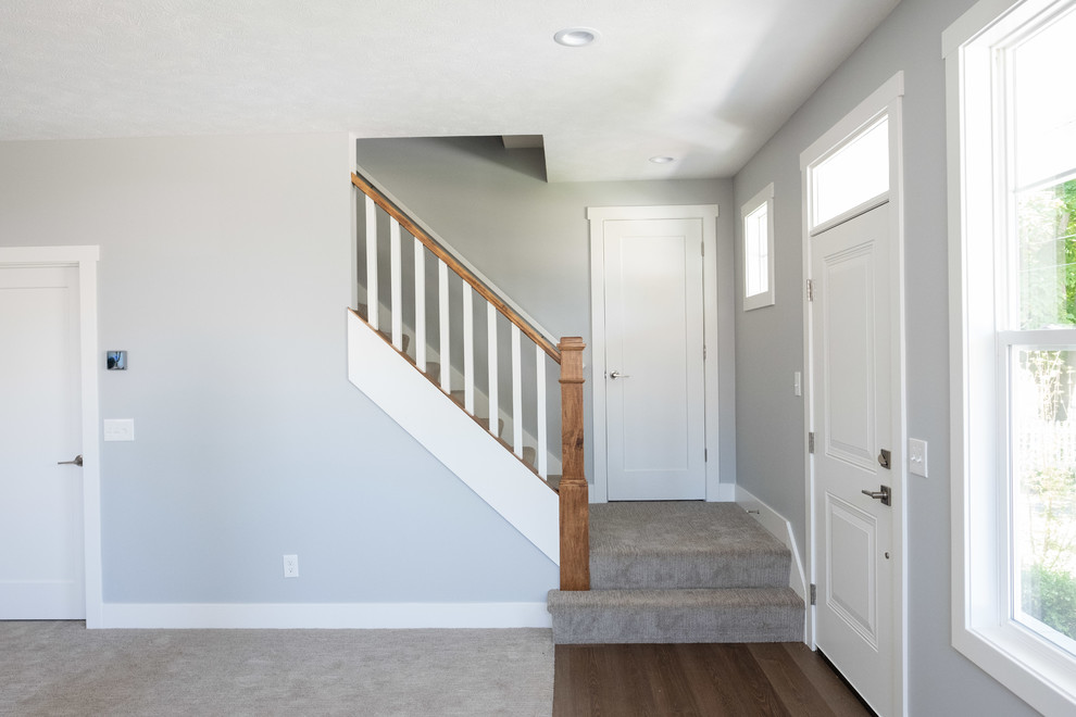 This is an example of a medium sized traditional carpeted straight wood railing staircase in Grand Rapids with carpeted risers.