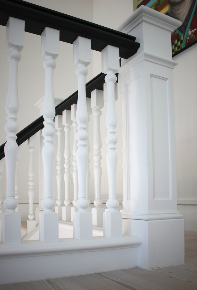 Пример оригинального дизайна: огромная п-образная деревянная лестница в стиле неоклассика (современная классика) с деревянными ступенями и деревянными перилами