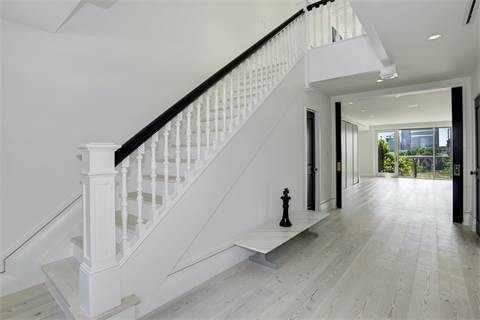 Стильный дизайн: огромная п-образная деревянная лестница в стиле неоклассика (современная классика) с деревянными ступенями и деревянными перилами - последний тренд