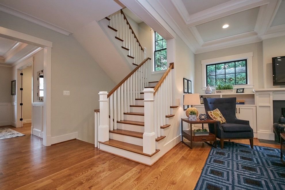 This is an example of a medium sized country wood u-shaped wood railing staircase in DC Metro with painted wood risers and feature lighting.