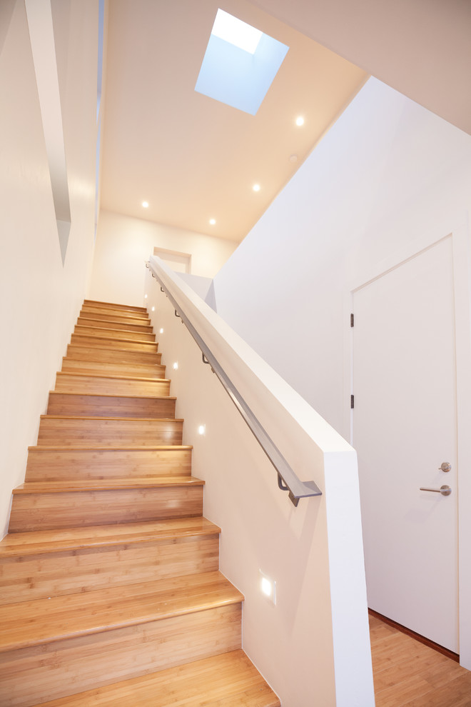 Foto de escalera recta minimalista de tamaño medio con escalones de madera, contrahuellas de madera y barandilla de metal