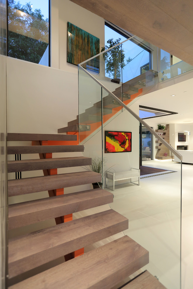 На фото: угловая металлическая лестница среднего размера в современном стиле с деревянными ступенями с