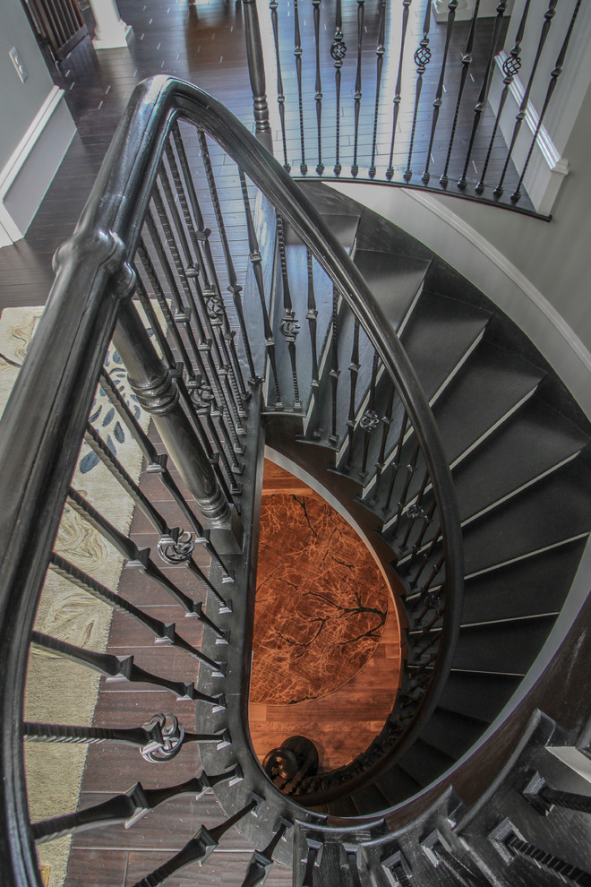 Inspiration for an expansive traditional wood curved mixed railing staircase in DC Metro with wood risers.