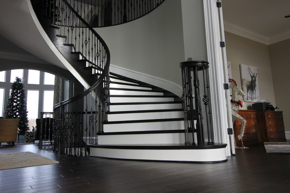 Imagen de escalera curva tradicional renovada extra grande con escalones de madera, contrahuellas de madera y barandilla de varios materiales