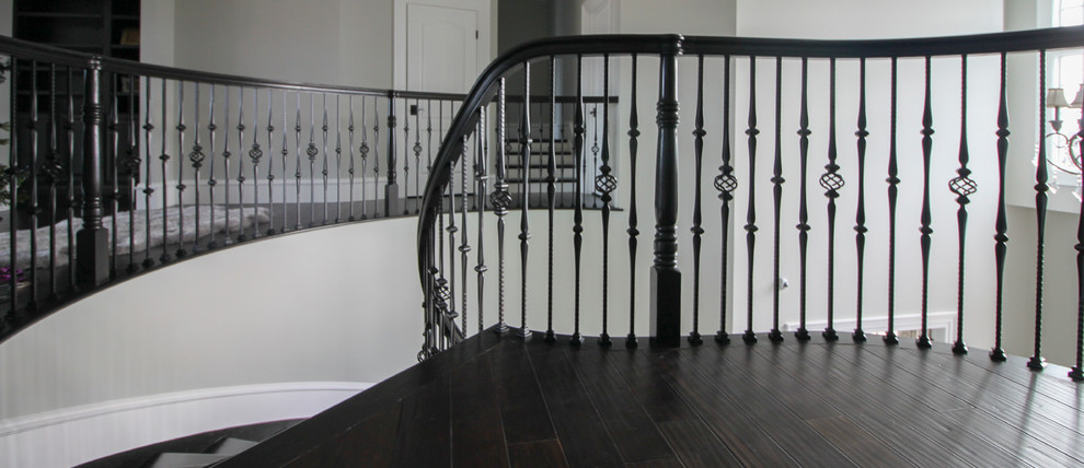 Modelo de escalera curva tradicional renovada extra grande con escalones de madera, contrahuellas de madera y barandilla de varios materiales