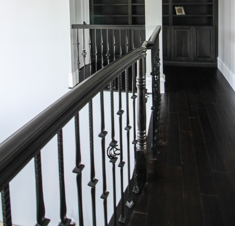 Cette photo montre un très grand escalier courbe chic avec des marches en bois, des contremarches en bois et un garde-corps en matériaux mixtes.