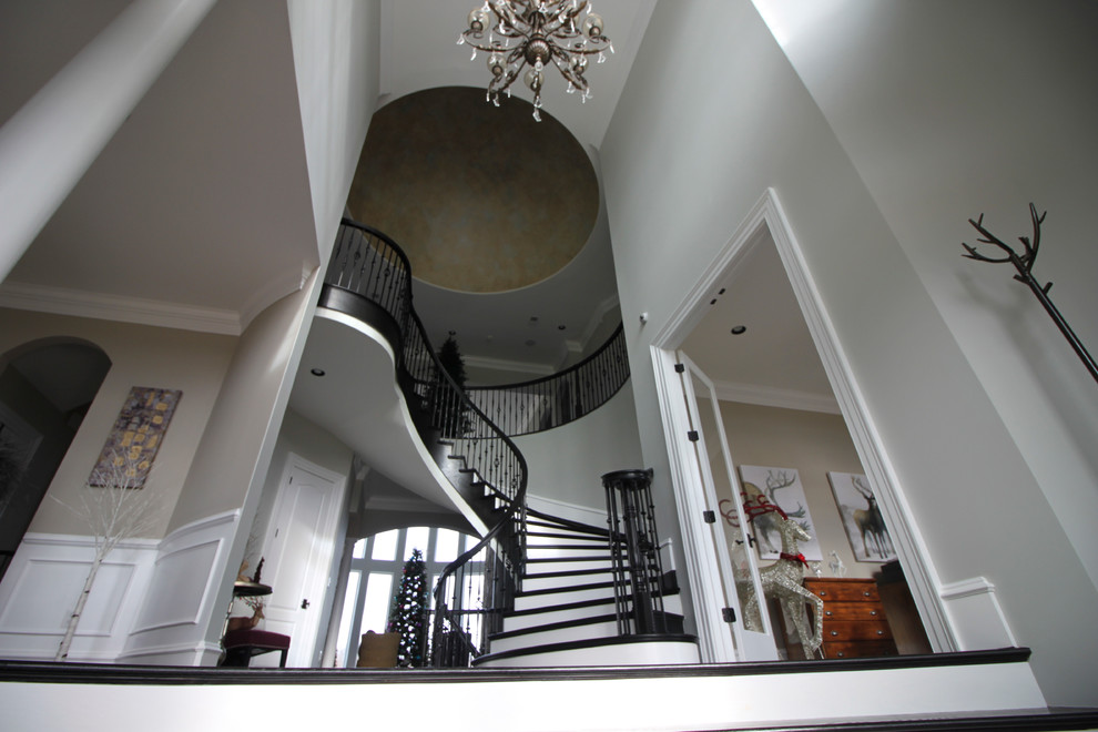 Inspiration for a huge transitional wooden curved mixed material railing staircase remodel in DC Metro with wooden risers