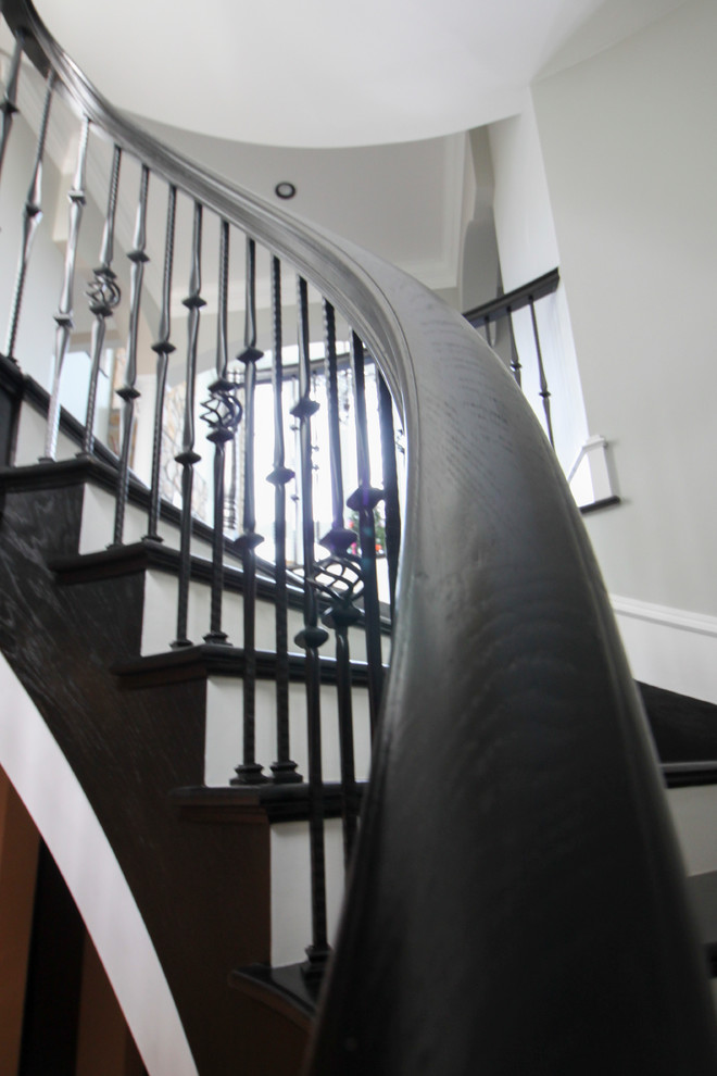 Ejemplo de escalera curva tradicional renovada extra grande con escalones de madera, contrahuellas de madera y barandilla de varios materiales