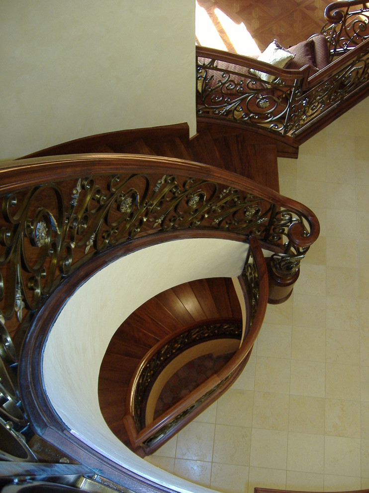 Ejemplo de escalera suspendida mediterránea extra grande con escalones de madera, contrahuellas de madera y barandilla de madera