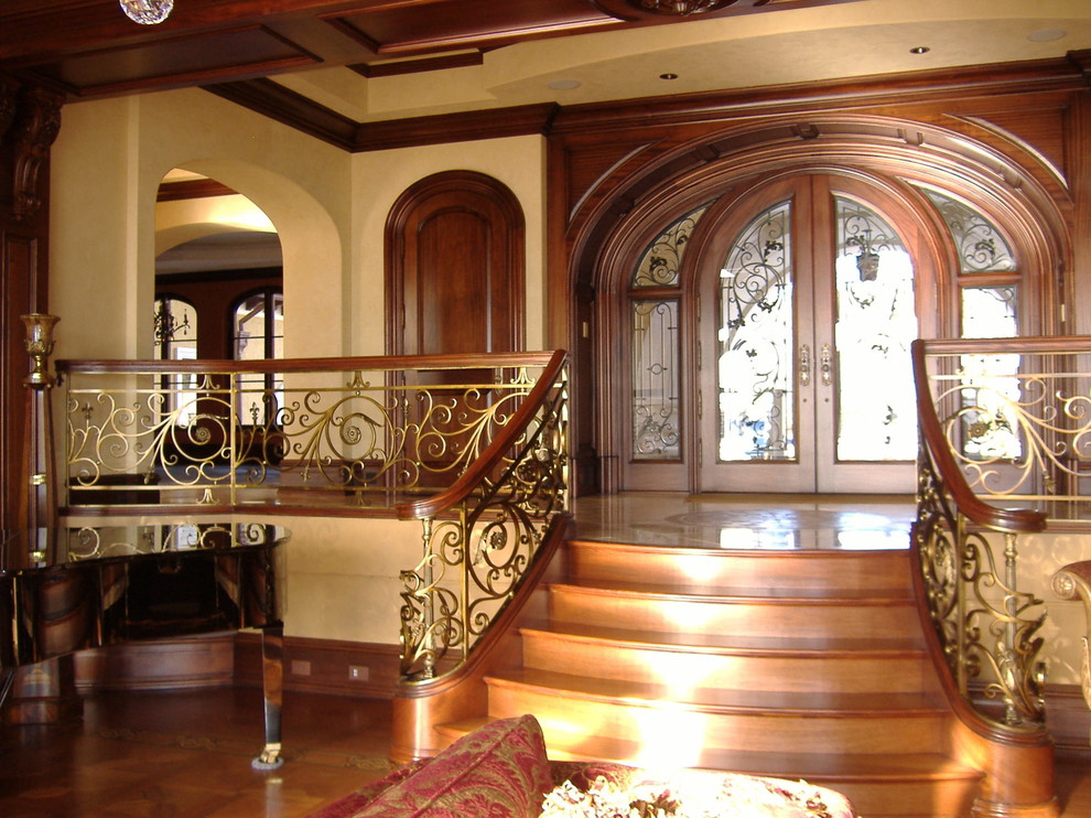 Пример оригинального дизайна: огромная деревянная лестница на больцах в средиземноморском стиле с деревянными ступенями и деревянными перилами