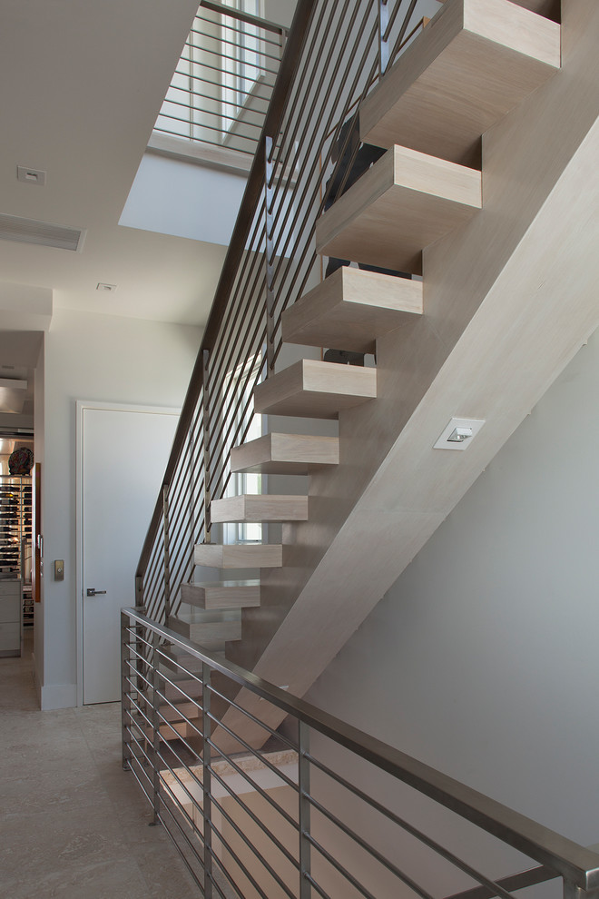 Cette photo montre un escalier sans contremarche flottant tendance de taille moyenne avec des marches en bois et un garde-corps en métal.