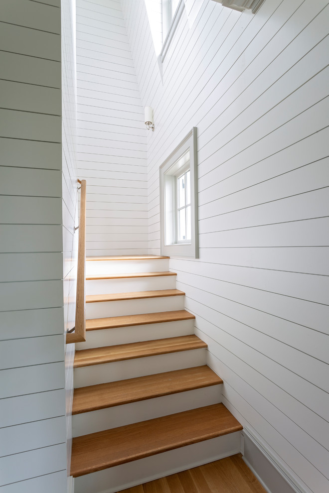 Idée de décoration pour un escalier peint marin avec des marches en bois et un garde-corps en bois.