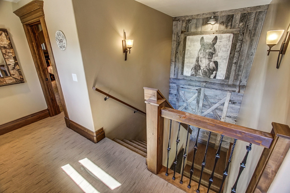 This is an example of a medium sized rustic carpeted u-shaped mixed railing staircase in Boise with carpeted risers.