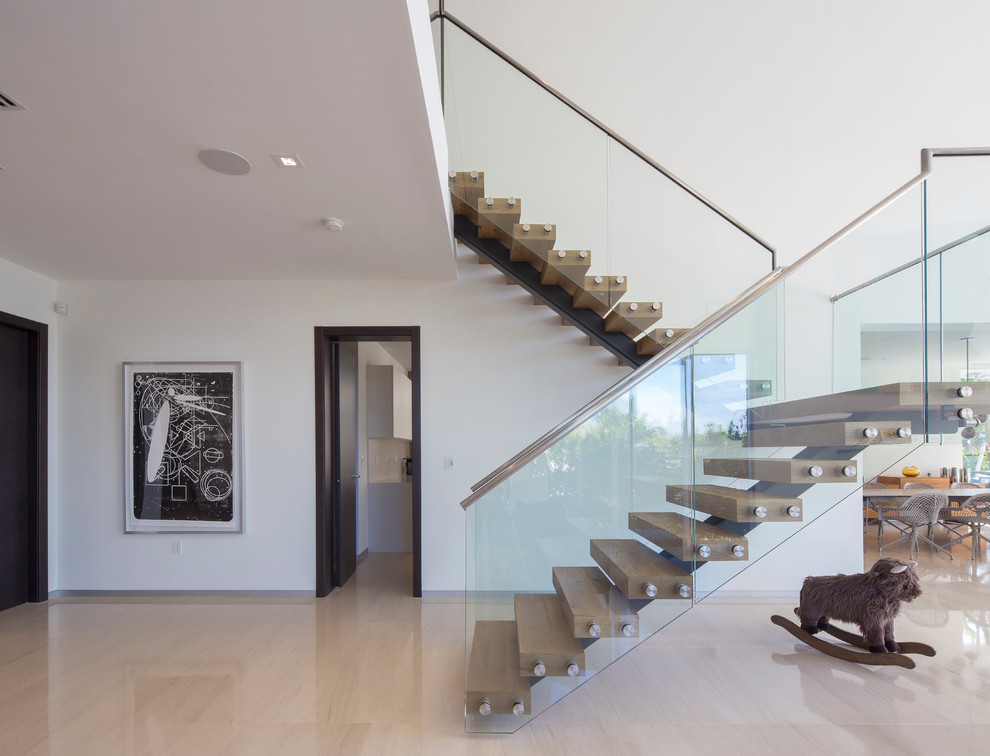 Идея дизайна: лестница на больцах в современном стиле с деревянными ступенями и стеклянными перилами без подступенок