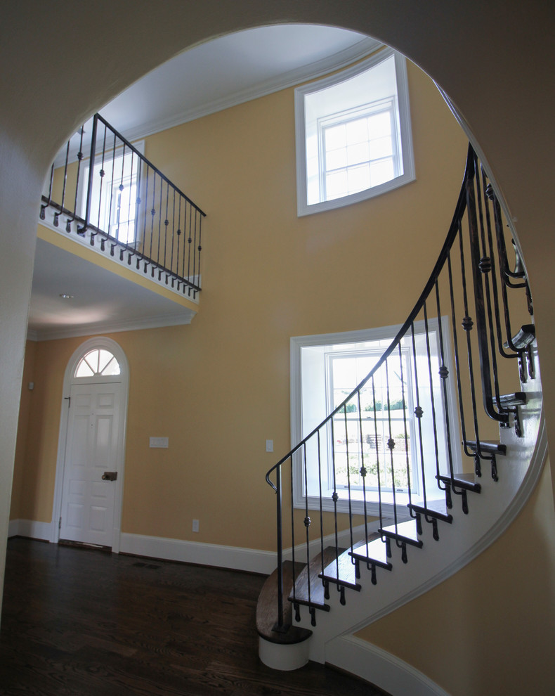 Идея дизайна: изогнутая деревянная лестница среднего размера в классическом стиле с деревянными ступенями и металлическими перилами