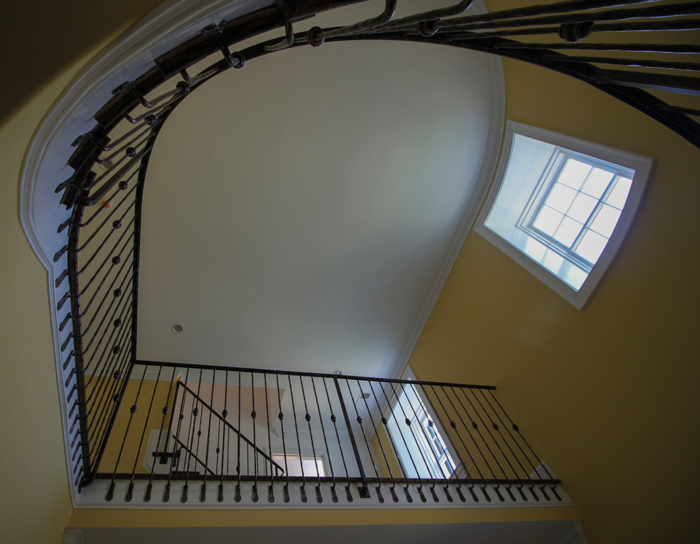Свежая идея для дизайна: изогнутая деревянная лестница среднего размера в классическом стиле с деревянными ступенями и металлическими перилами - отличное фото интерьера