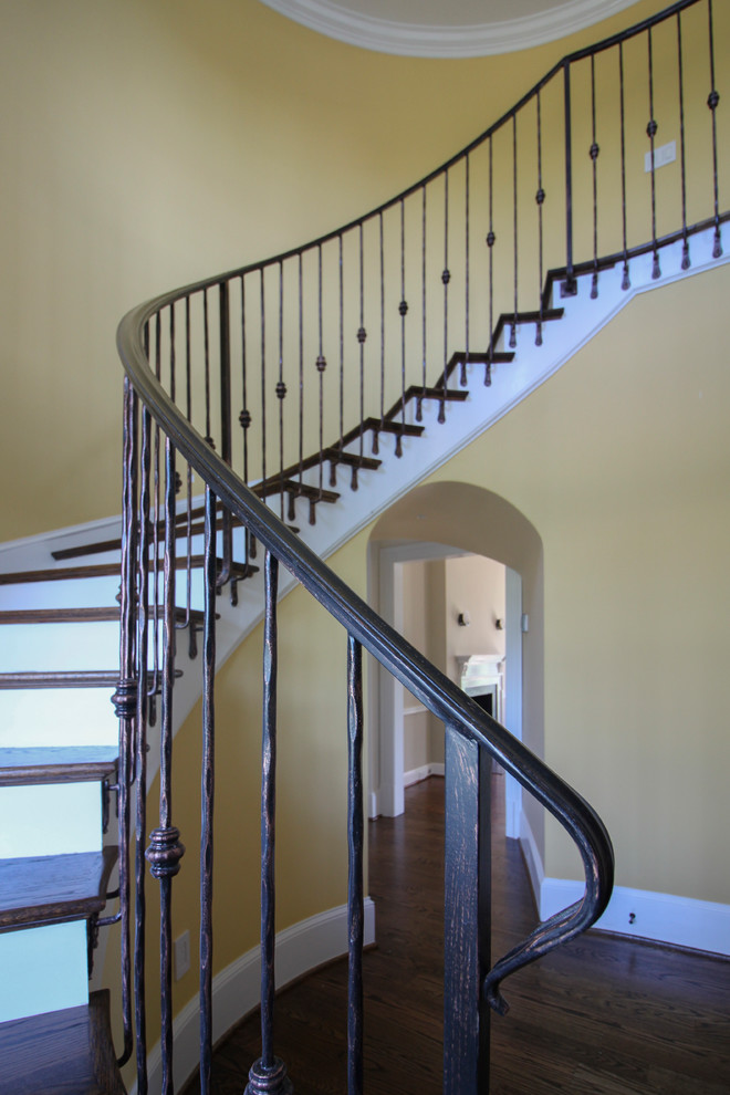 Inspiration for a mid-sized timeless wooden curved metal railing staircase remodel in DC Metro with wooden risers