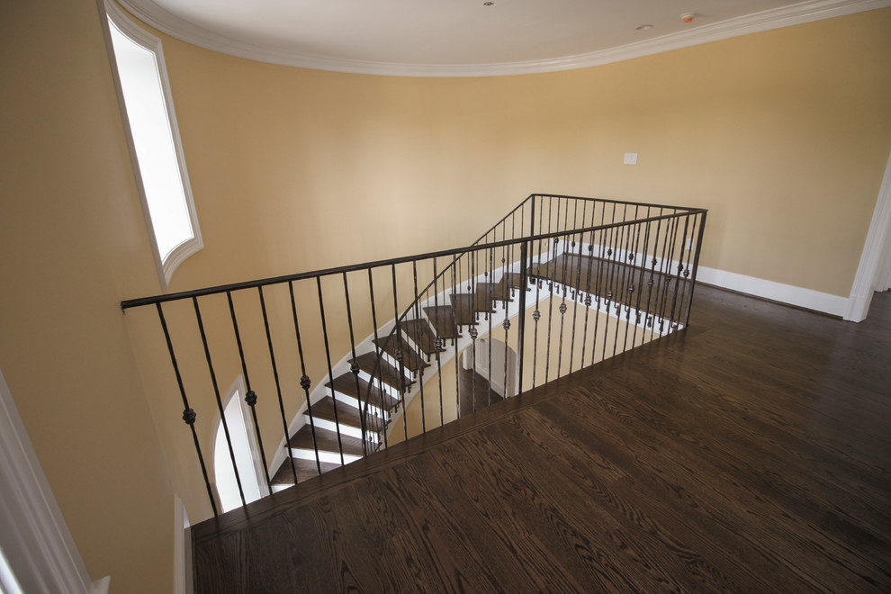 Свежая идея для дизайна: изогнутая деревянная лестница среднего размера в классическом стиле с деревянными ступенями и металлическими перилами - отличное фото интерьера
