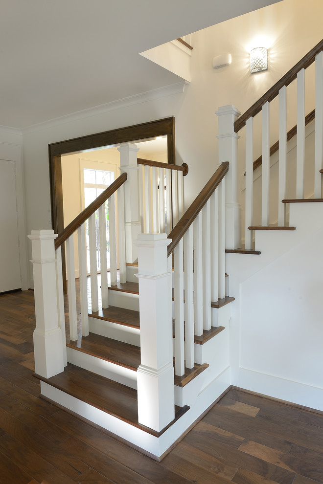Large elegant wooden l-shaped staircase photo in Houston with painted risers