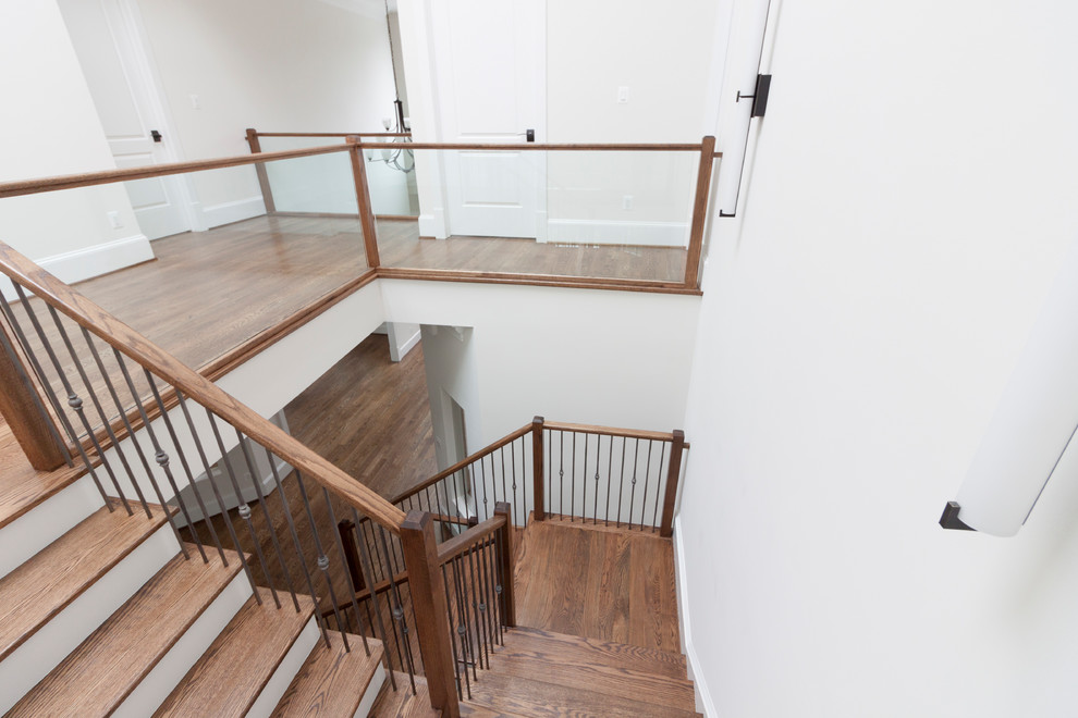 Ejemplo de escalera suspendida contemporánea extra grande con escalones de madera, contrahuellas de madera y barandilla de vidrio
