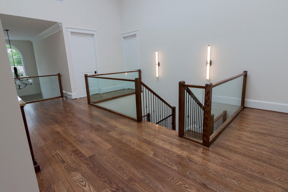 Exemple d'un très grand escalier flottant tendance avec des marches en bois, des contremarches en bois et un garde-corps en verre.