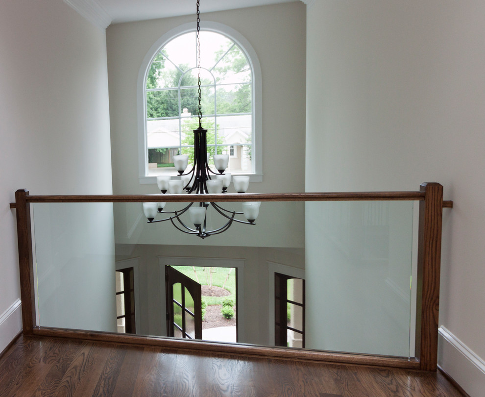 Foto de escalera suspendida actual extra grande con escalones de madera, contrahuellas de madera y barandilla de vidrio