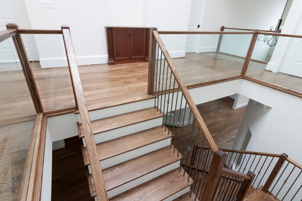 Example of a huge trendy wooden floating glass railing staircase design in DC Metro with wooden risers
