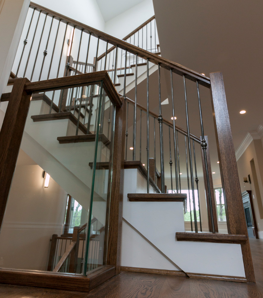 Cette photo montre un très grand escalier flottant tendance avec des marches en bois, des contremarches en bois et un garde-corps en verre.