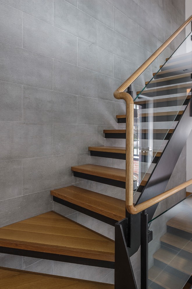 Ejemplo de escalera actual sin contrahuella con escalones de madera y barandilla de vidrio