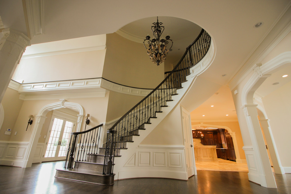 Diseño de escalera curva clásica de tamaño medio con escalones de madera, contrahuellas de madera y barandilla de varios materiales