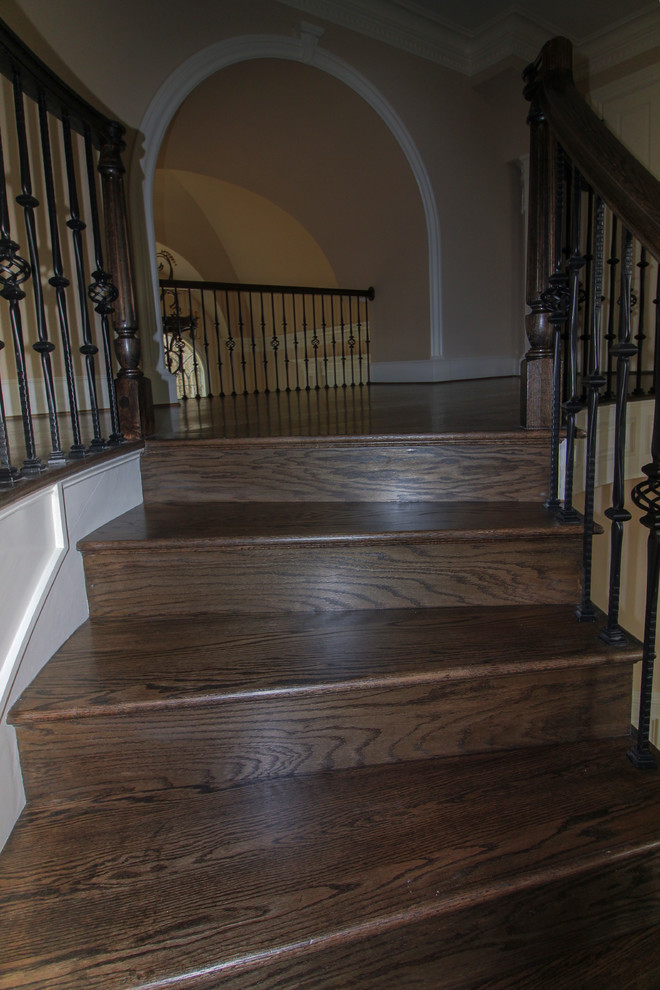 Cette image montre un escalier courbe traditionnel de taille moyenne avec des marches en bois, des contremarches en bois et un garde-corps en matériaux mixtes.