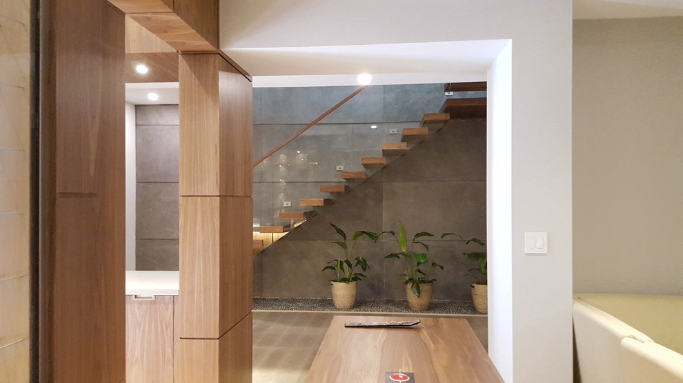 Идея дизайна: лестница на больцах, среднего размера в современном стиле с деревянными ступенями и стеклянными перилами без подступенок