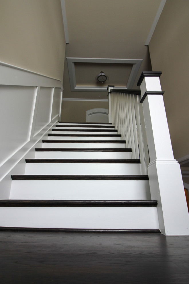 Cette image montre un grand escalier minimaliste en U avec des marches en bois, des contremarches en bois et un garde-corps en bois.